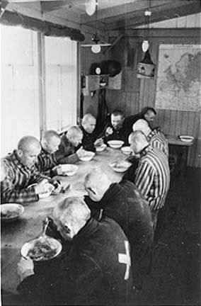 Sachsenhausen prisoners eat in the mess hall of their barracks